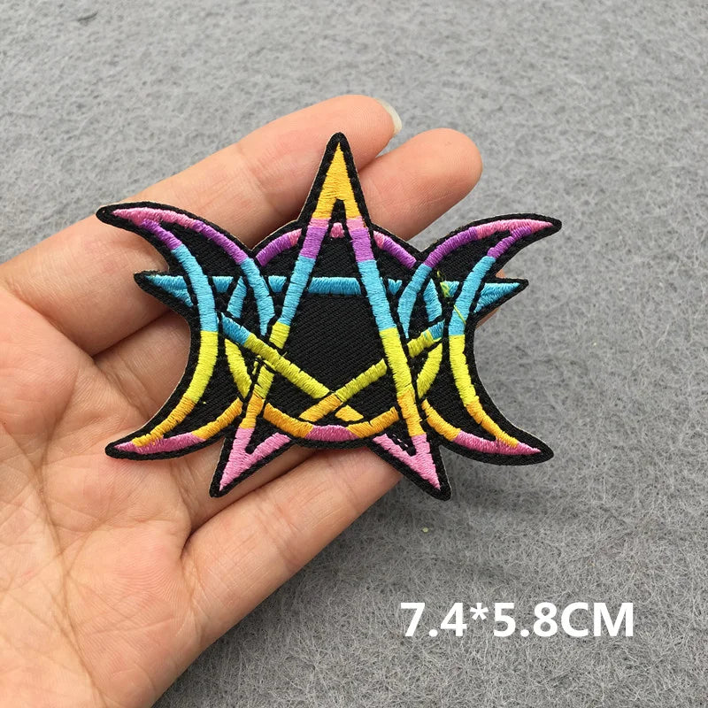 Colorful star-shaped patch held in a hand with dimensions displayed.