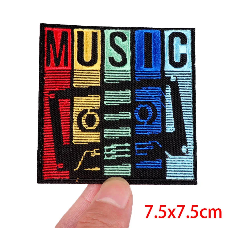 Colorful 'MUSIC' patch held by a thumb with dimensions indicated