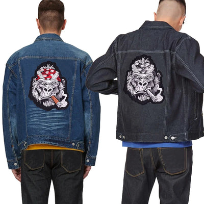 Two denim jackets with a graphic design on the back, one blue and one black.
