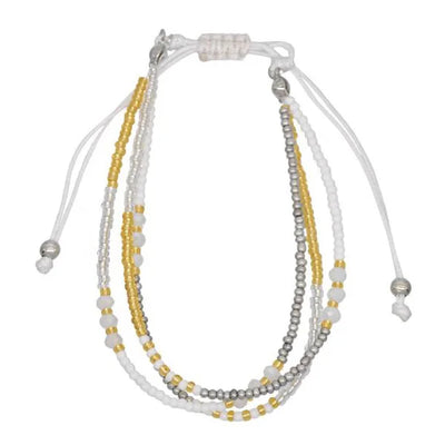 Multistrand beaded bracelet with white, gold, and gray beads on a white background