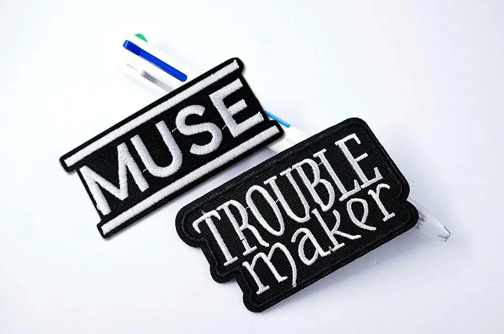Two patches with 'MUSE' and 'TRouble Maker' text on a white background