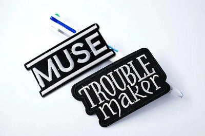 Two patches with 'MUSE' and 'TRouble Maker' text on a white background