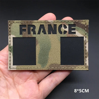 FRANCE flag Camouflage patch  held in a hand against a dark background