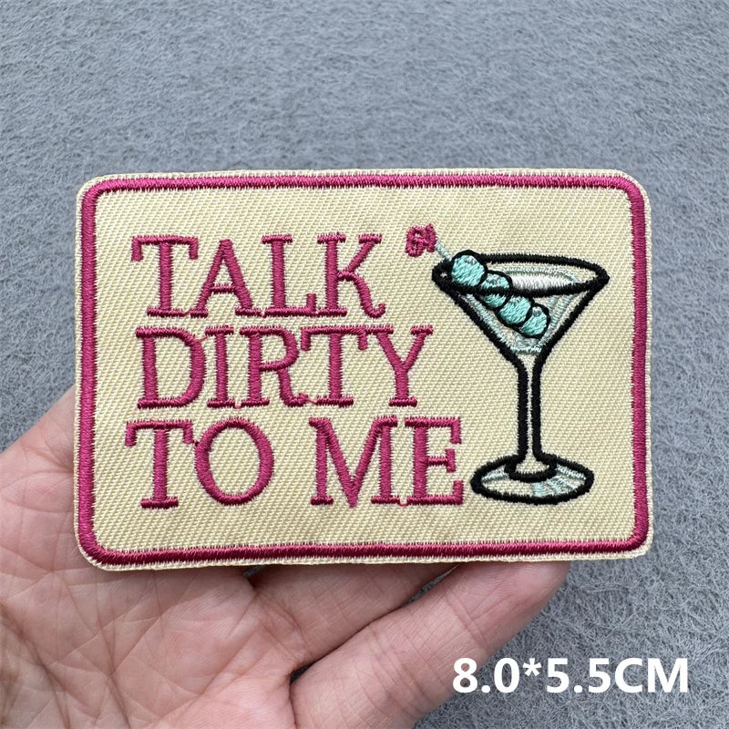 Patch with 'Talk Dirty to Me' text and a martini glass held in a hand against a gray background.
