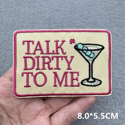 Patch with 'Talk Dirty to Me' text and a martini glass held in a hand against a gray background.