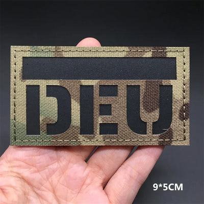 Germany flag Camouflage patch held by a hand on a dark background