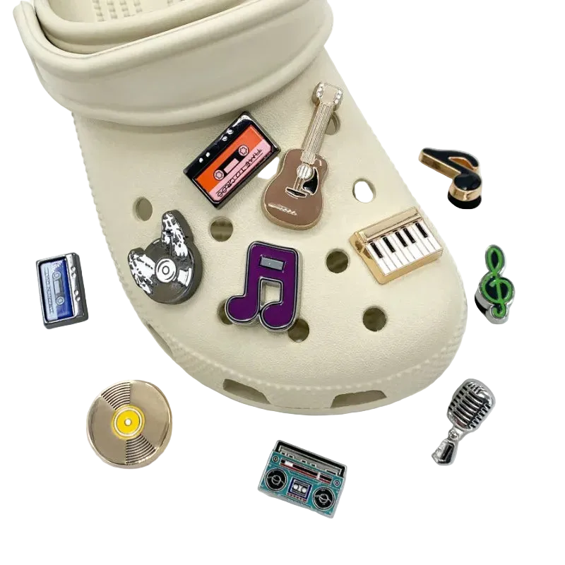 Beige croc shoe with various music-themed charms on a white background