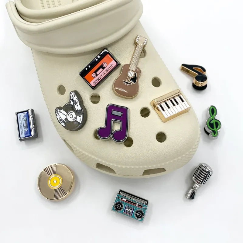 Beige croc shoe with music-themed charms on a white background