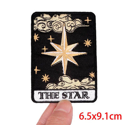 Embroidered patch with star design and 'The Star' text, held by a hand.