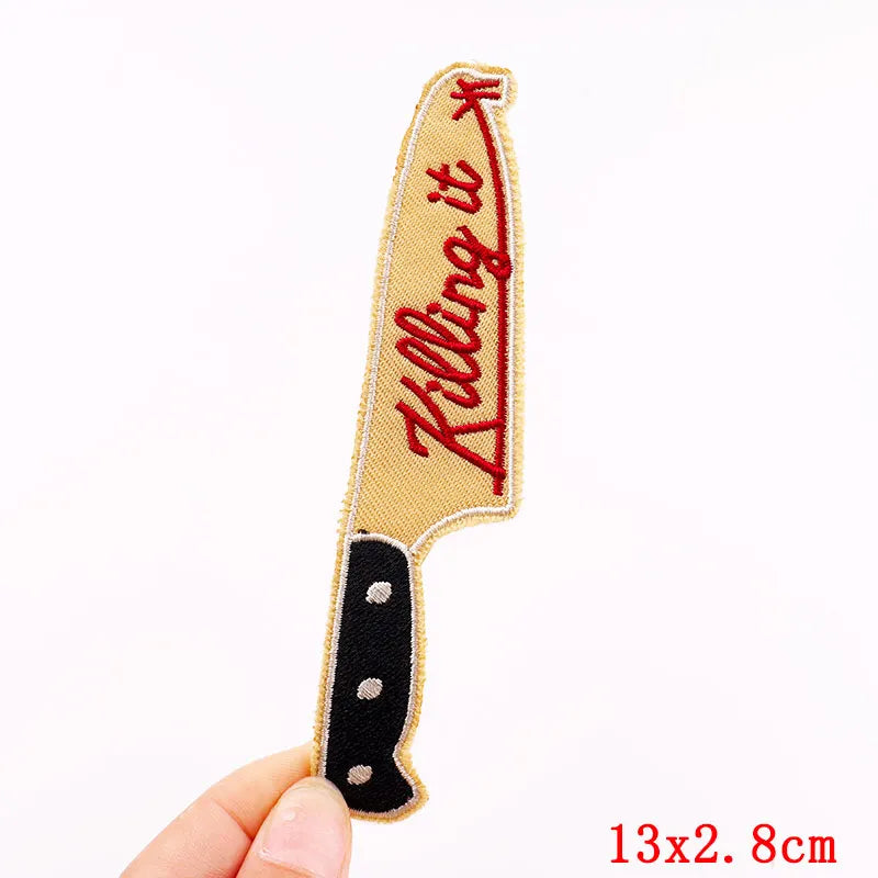 Knife-shaped patch with 'Killing It' text held by a hand on a white background