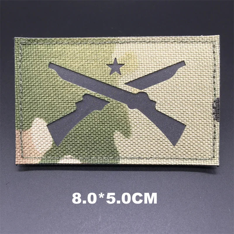 Multicam patch with crossed rifles and a star on a dark background
