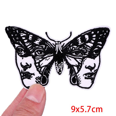 Butterfly patch with face design held by a hand, size 9x5.7cm