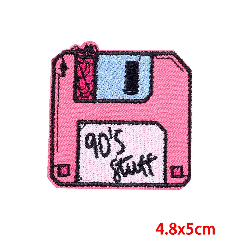 Pink floppy disk patch with '90s stuff' text on a white background