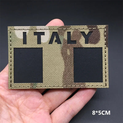 Italy flag Camouflage patch held in a hand against a dark background