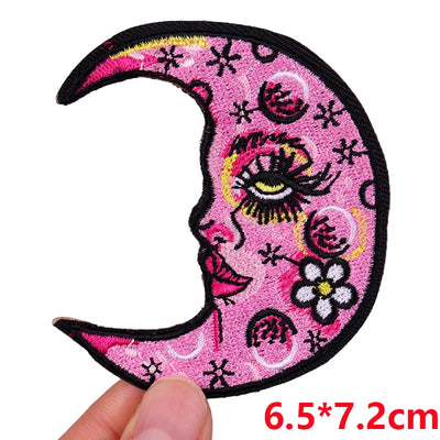 Pink crescent moon patch with face design held by a hand, size 6.5*7.2cm.