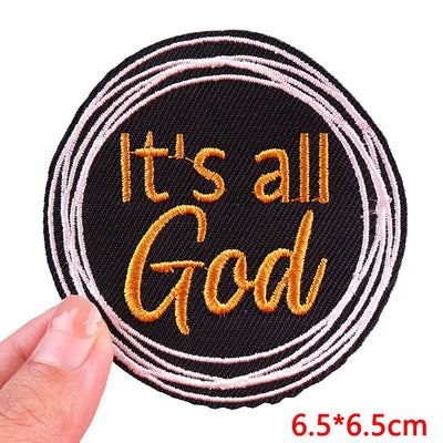 Circular patch with 'It's all God' text held by a hand, on a white background
