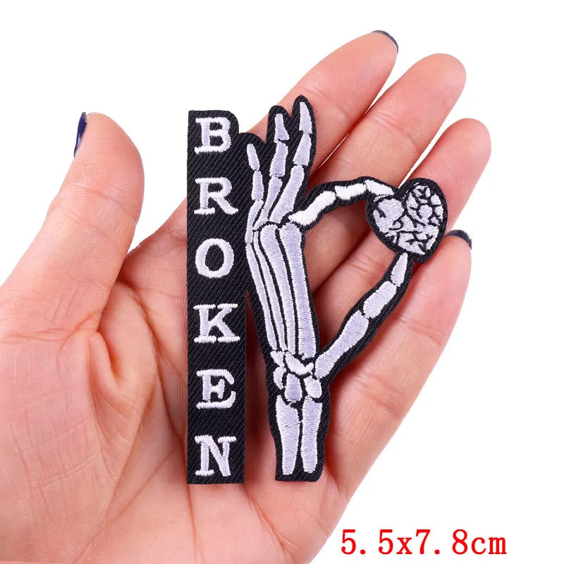 Patch with skeleton hand and 'BROKEN' text held in a hand, size 5.5x7.8cm.