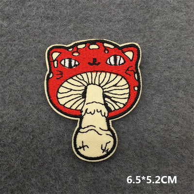 Embroidered patch of a cat face on a mushroom with dimensions 6.5*5.2CM on a dark gray background.