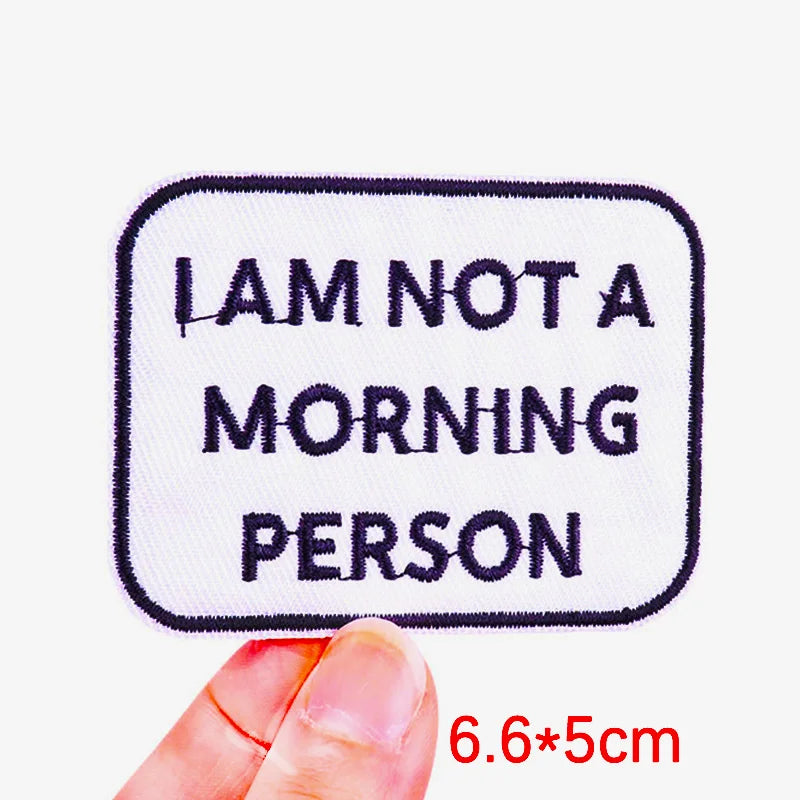 Embroidered patch with 'I AM NOT A MORNING PERSON' text held by a hand on a white background.