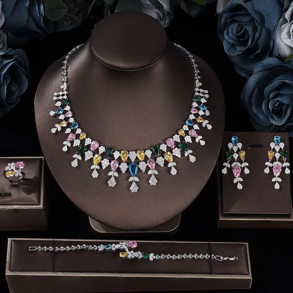 Jewelry set including a necklace, earrings, ring and bracelet on a dark background with flowers.