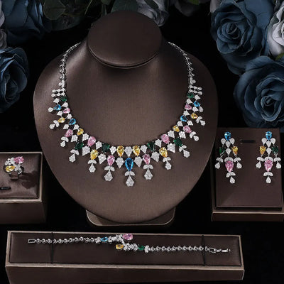 Jewelry set including a necklace, earrings, ring and bracelet on a dark background with flowers.