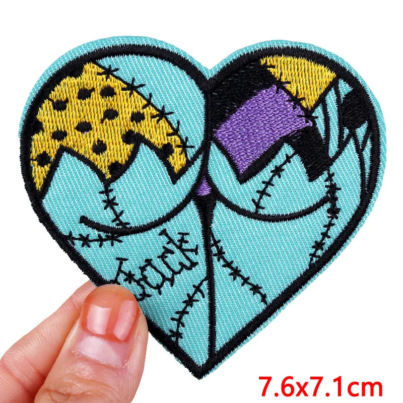 Heart-shaped patch with cartoon design held by a hand, on a white background
