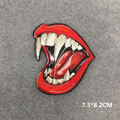 Embroidered patch of a mouth with red lips and white teeth on a gray background