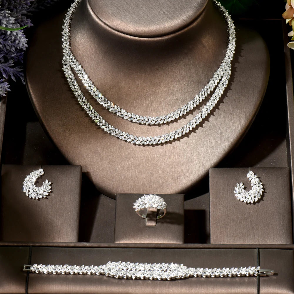 Jewelry set including necklace, earrings, ring and bracelet on a brown stand.