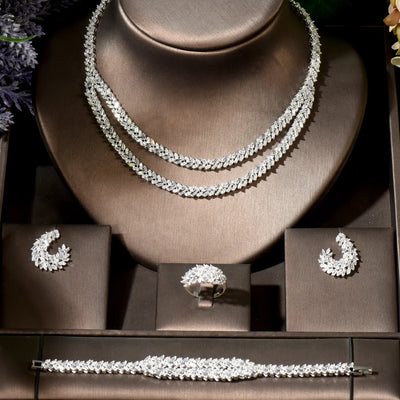 Jewelry set including necklace, earrings, ring and bracelet on a brown stand.