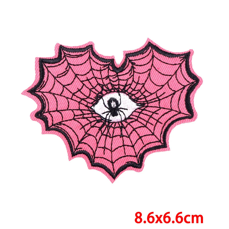 Pink spider web patch with a spider in the center on a white background