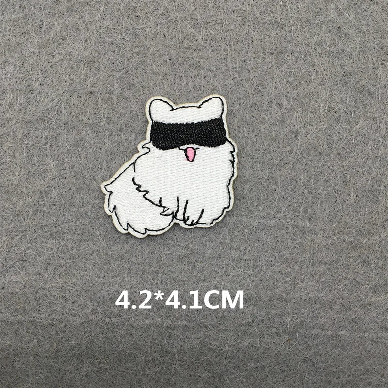 Embroidered patch of a cartoon cat with a blindfold on a gray background