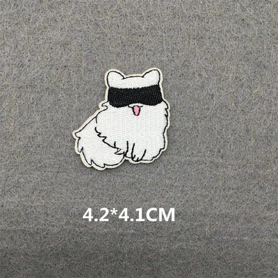 Embroidered patch of a cartoon cat with a blindfold on a gray background