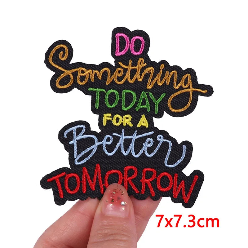 Motivational patch with colorful text held by a hand on a white background