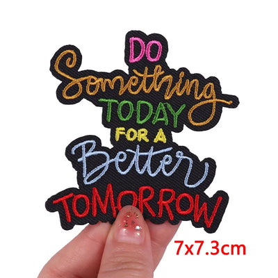 Motivational patch with colorful text held by a hand on a white background