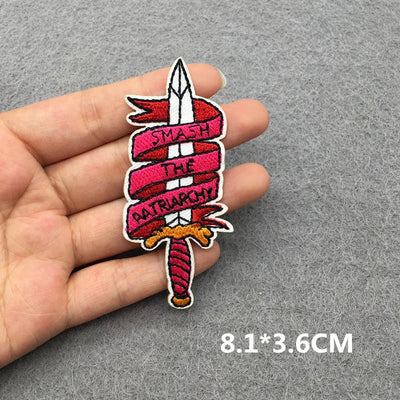 Patch with text held between fingers on a gray background