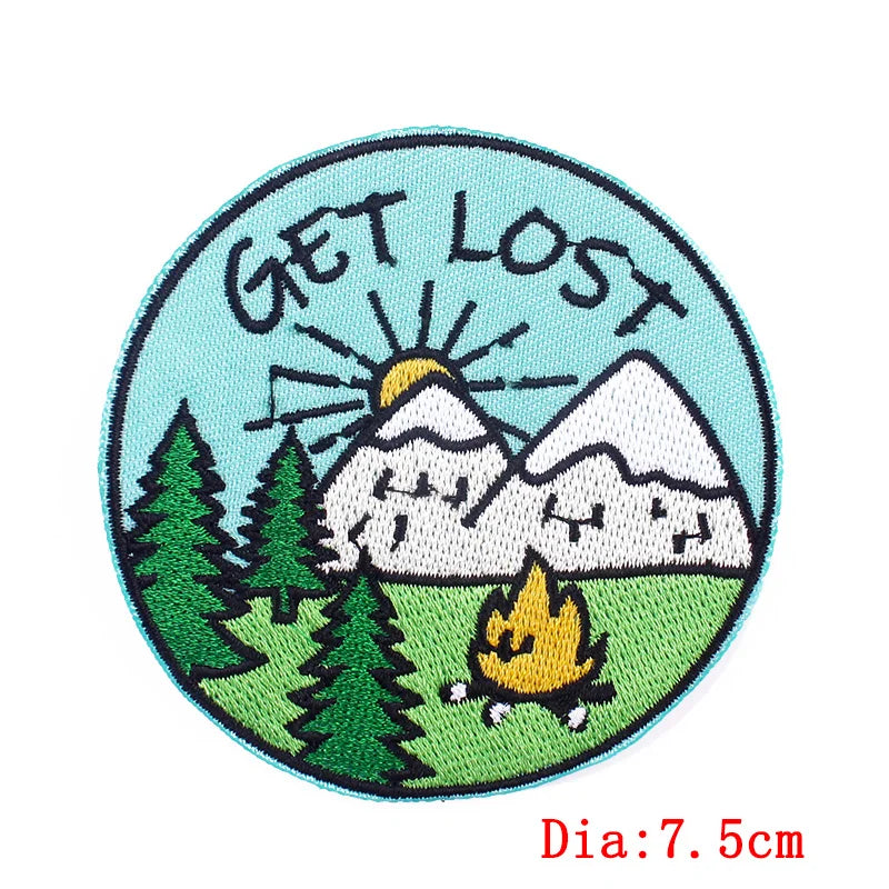 Circular patch with mountains, trees, and a campfire, featuring the text 'GET LOST'.