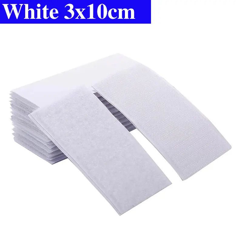 Stack of white Velcro pads with dimensions 3x10cm on a white background