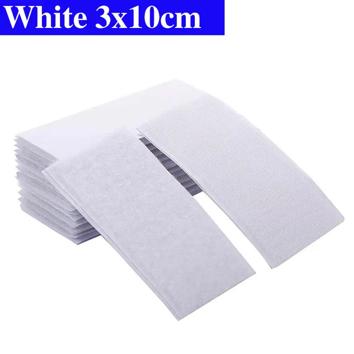 Stack of white Velcro pads with dimensions 3x10cm on a white background