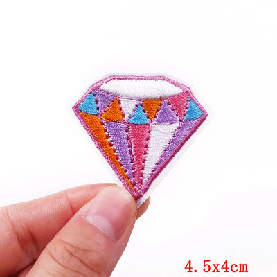 Colorful diamond-shaped patch held by a hand with a white background