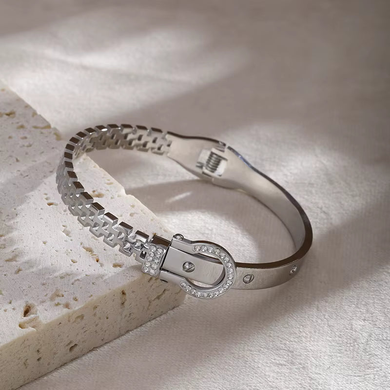 Silver bracelet with a clasp on a textured surface