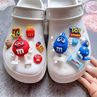 White clogs with colorful character and candy decorations on a textured surface.