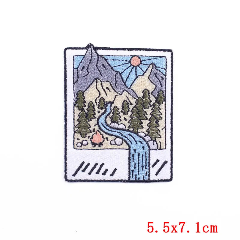 Embroidered patch of a mountain landscape with trees and a stream, size 5.5x7.1cm.