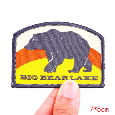 Patch with bear silhouette and 'Big Bear Lake' text held by a hand on a white background