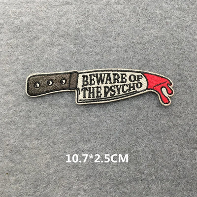 Patch of a knife with 'Beware of the Psycho' text on a gray background