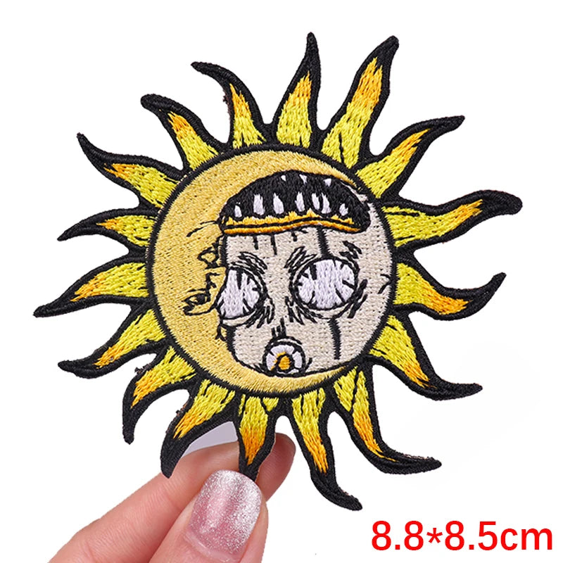Sun-shaped patch with a face design held by a hand on a white background