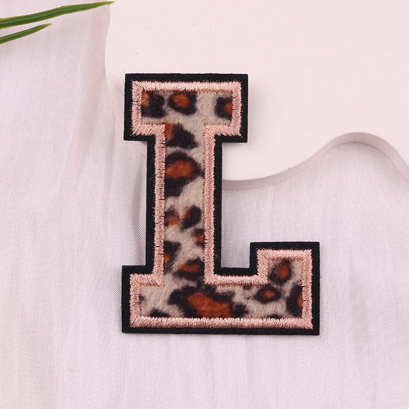 Leopard print letter 'L' patch on a white fabric background