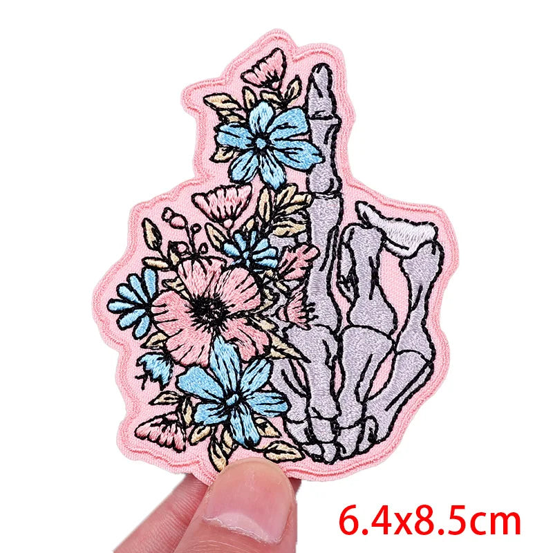 Floral and shell design patch held by a hand with dimensions displayed.