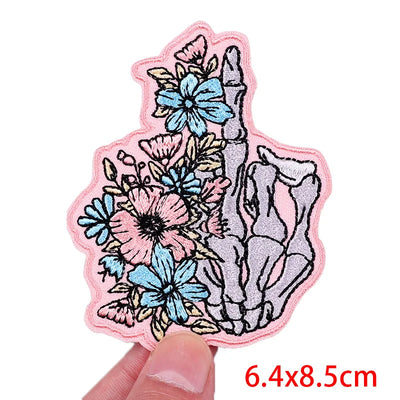 Floral and shell design patch held by a hand with dimensions displayed.