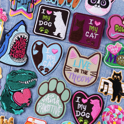 Collection of colorful patches with various designs on a denim background