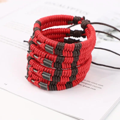 Red and black braided bracelets on a white surface